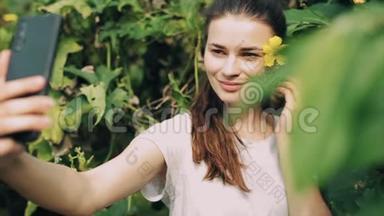 一个美丽的白种人女孩带着黄色的花在外面自拍。 树木。