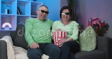 年长的男<strong>人</strong>和女<strong>人</strong>一起看电视，<strong>坐</strong>在<strong>沙发上</strong>看一部迷<strong>人</strong>的3D眼镜电影。 高级