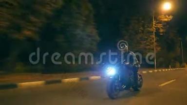 摩托车手在夜间公路上飙车。年轻人骑着现代运动摩托车在夜街上疾驰