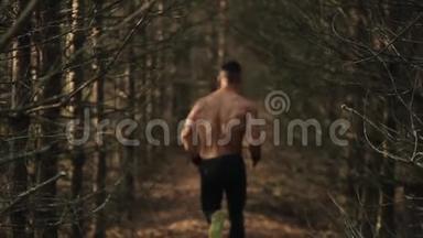 年轻的肌肉男在初秋的森林里沿着小径奔跑。 跑步<strong>运动</strong>员在大自然的道路上冲刺