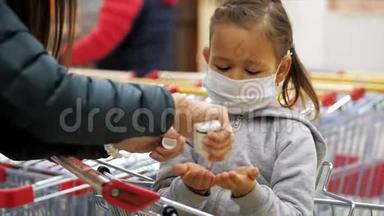 儿童戴防护面罩，在杂货店用消毒器消毒双手。