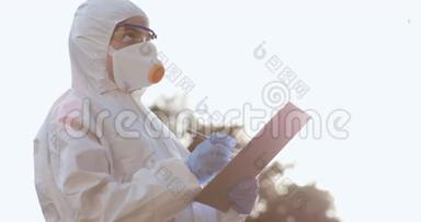 自信的亚洲医生，穿着防护PPE西装，戴着口罩和眼镜