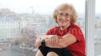 穿着t恤看镜头的退休妇女的<strong>肖像</strong>。 坐在窗台上看着<strong>老人</strong>和蔼的养老<strong>老人</strong>