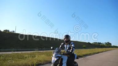 戴头盔的人在高速公路上骑摩托车骑得很快。 摩托车手在风景优美的自然景观中骑摩托车