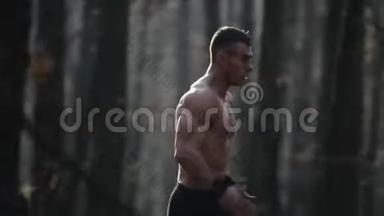 年轻的肌肉运动员在森林里<strong>奔跑</strong>。 在树之间<strong>奔跑</strong>。