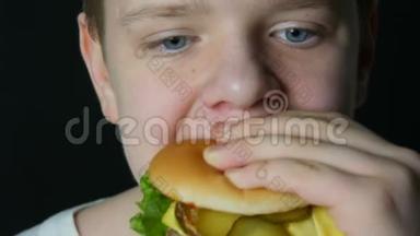 <strong>一个</strong>十几岁的男孩的<strong>嘴</strong>，他吃两个多汁的汉堡，<strong>一个</strong>芝士汉堡或汉堡，里面有奶酪、肉切片和泡菜