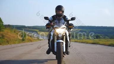 戴着头盔的人驾驶着强大的摩托车在高速公路上，背景美丽。 摩托车超速驾驶