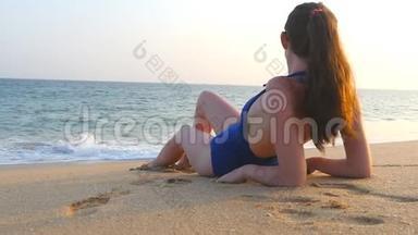 穿着泳衣躺在<strong>海边</strong>和日光浴的年轻女孩。 美丽的白种人女人在<strong>海边</strong>放松