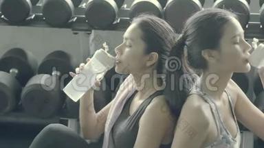 美丽的年轻亚洲女人在<strong>健身房</strong>锻炼后用新鲜的饮料放松饮用水，亚洲女孩<strong>休息</strong>锻炼锻炼<strong>休息</strong>