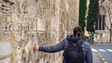 人手划面，在巴塞罗那哥特式街区旧建筑石壁上滑动，旅行