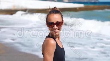 <strong>喜笑颜开</strong>的女人穿着泳衣和太阳镜，邀请男朋友带着海浪在阳光明媚的海边散步