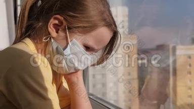 检疫，威胁冠状病毒.. 悲伤的孩子戴<strong>着</strong>防护医疗面具坐在窗台上，<strong>看着窗外</strong>。 病毒