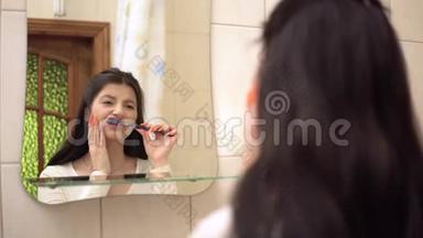 年轻女子刷牙时，牙痛感<strong>强</strong>烈，抚摸着她的脸颊