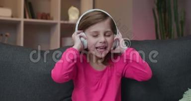 可爱的快乐<strong>小女孩听音乐</strong>无线耳机。 有趣的<strong>小女孩</strong>跳舞，唱歌和律动