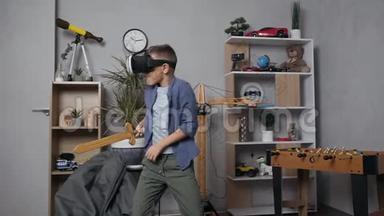 一个英俊的十几岁男孩在他的游戏室里用特殊的虚拟3D眼镜与玩具剑搏斗