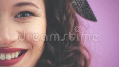 半边脸的迷人的年轻女孩扭结的头发和黑色的头巾正在看着相机，微笑。