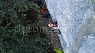 女人在艰难的运动路线上攀爬，攀岩者艰难地移动，跌倒