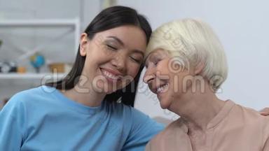 友善的年轻女士微笑着<strong>对待</strong>幸福的高级女士，帮助老年人，照顾家庭