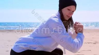 女孩在海沙滩健身户外运动训练上蹲。
