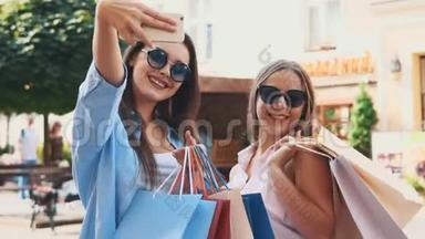 微笑的十几岁女孩正在通过智能手机自拍，正在夏季城市公园的背景。 他们正在购物