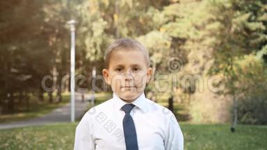 一幅八岁男孩的画像，他是一个在公园里有<strong>商业风</strong>格的英俊男孩