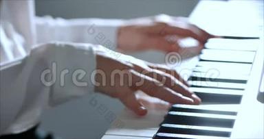 女或女学生或职业<strong>钢琴</strong>家在一架漂亮的白色<strong>钢琴</strong>上演奏古典音乐，<strong>钢琴</strong>家的手
