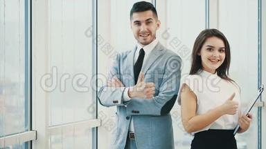 两个商人正微笑着寻找相机，拇指手指向上，孤立在白色全景背景上。 关门