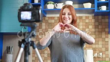 食品博客女孩影响者正在厨房录制视频或播客。 使生活方式博客vlog，显示心脏
