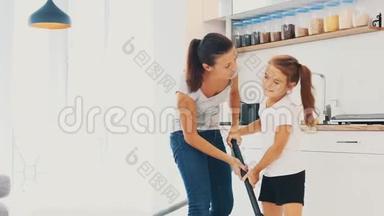 带着女儿的女人正在用没有刷子的白色瓷砖吸尘厨房地板，<strong>只有</strong>吸尘器的管道