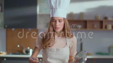 厨师在炉子上煮汤。 在家准备晚餐的女人