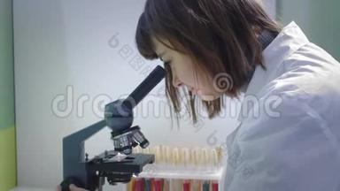 年轻的女<strong>科学家</strong>透过显微镜看。 她研究样本。 一位年轻的<strong>科学家</strong>进行科学研究