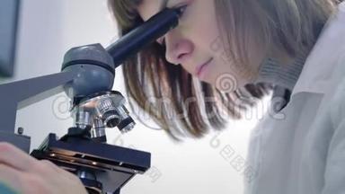 年轻的女<strong>科学</strong>家透过显微镜看。 她研究样本。 一位年轻的<strong>科学</strong>家进行<strong>科学</strong>研究