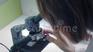 年轻的女<strong>科学</strong>家透过显微镜看。 她研究样本。 一位年轻的<strong>科学</strong>家进行<strong>科学</strong>研究