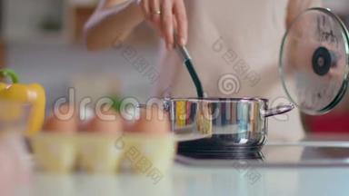 无法辨认的女人在厨房<strong>煮汤</strong>。 家庭主妇用勺子搅拌<strong>汤</strong>