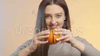 可爱的女孩互相摩擦一半的橘子，挤压果汁的过程，健康饮食的概念和生活方式