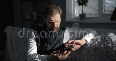 一个大胡子男人在家里用智能手机