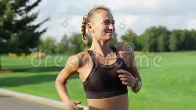 微笑的女运动员在绿色公园慢跑。 女人晨练