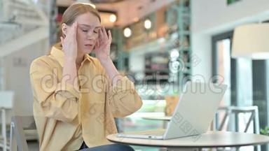 有头痛的年轻女子在咖啡厅使用笔记本电脑