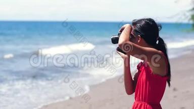 笨拙的女摄影师把单反相机丢在海滩上。