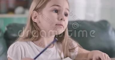 练习本中微笑的高加索女孩解决数学问题的肖像。 摄像机移向儿童`的脸