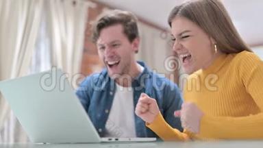 有吸引力的情侣在笔记本电脑上庆祝网上<strong>支付成功</strong>