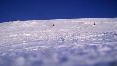 两个滑雪者在一个山脉的背景下<strong>降</strong>落在一个<strong>雪坡</strong>上。 在大雪纷飞的冬天，危险的自由