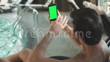 特写帅哥有视频电话与绿色屏幕电话。 带电话的男人