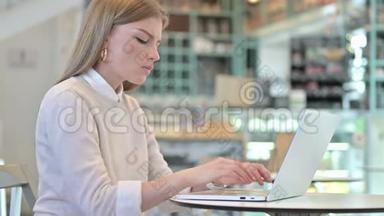 体贴的年轻女人在咖啡馆里用笔记本电脑工作