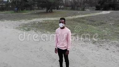 一个年轻的非洲男子站在森林小<strong>路</strong>上，脸上戴着<strong>医</strong>疗保护面罩。