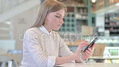 年轻女子在咖啡馆庆祝智能手机的成功