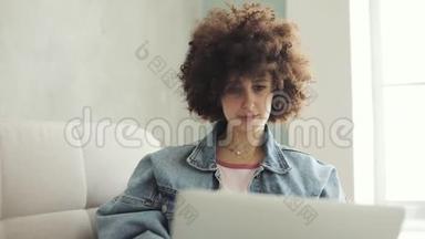 坐在沙发上的笔记本电脑上，有卷发的女人在社交媒体上留言。