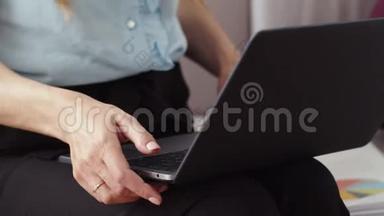 女商人在家里开始用笔记本电脑工作。 女孩在笔记本电脑上打字。