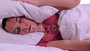 男人睡觉时被吵闹的坏房间邻居用枕头捂住耳朵，醒来后躺在床上