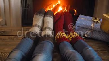 一对穿着羊毛袜的夫妇在平安夜的壁炉前度过浪漫之夜的慢镜头